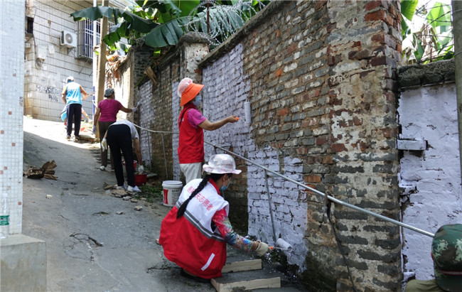 志愿者们粉刷老旧墙面。.jpg