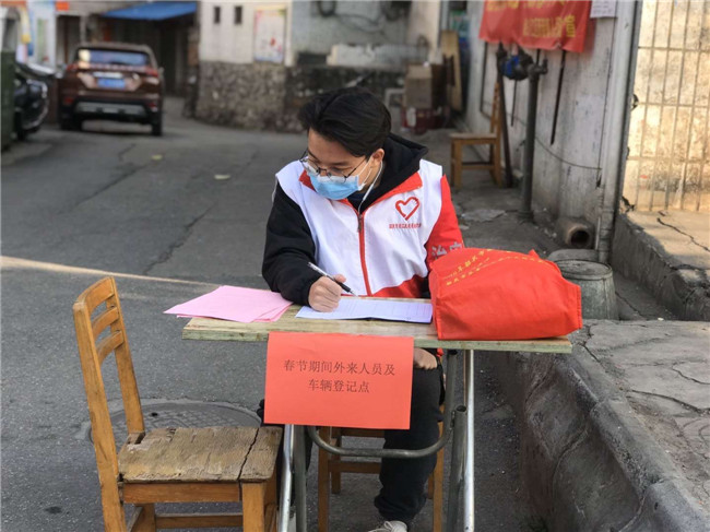 志愿者在社区进行春节期间外来人员及车辆登记工作.jpg