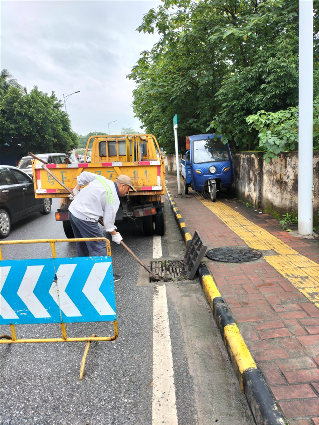 工作人员清理碧亭路下水道。.png