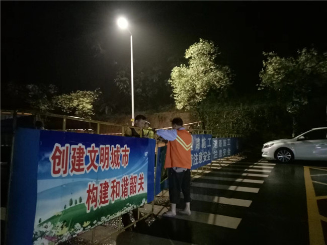 工作人员协助交警进行道路封闭工作.jpg