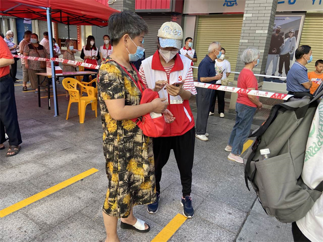 风采街组织志愿者帮助居民进行扫码.jpg