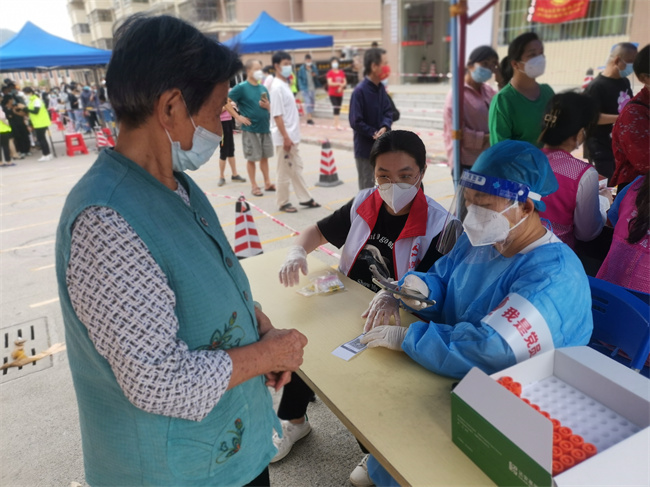 党员志愿者给居民核验核酸码.jpg