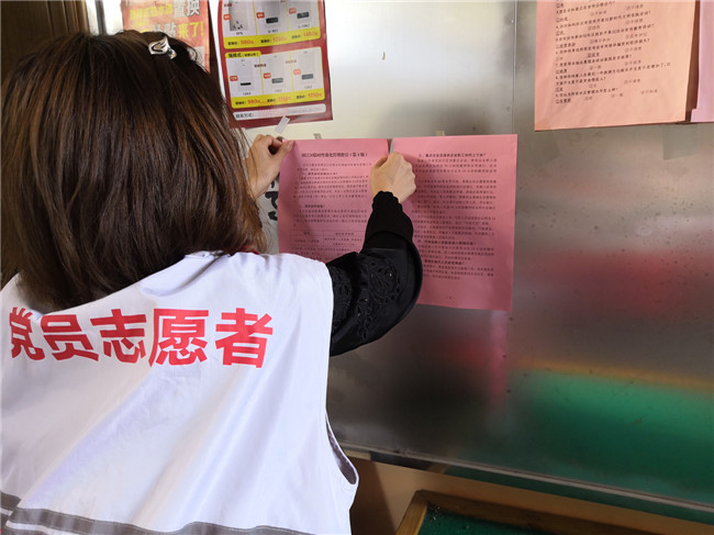 浈江区党员志愿者前往小区宣传栏张贴宣传资料.jpg