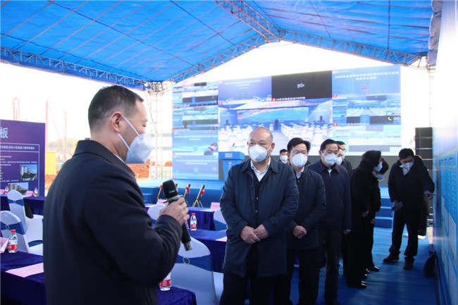 区领导在现场听取相关负责人介绍项目情况。.JPG