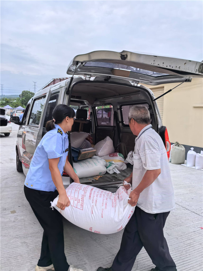 犁市镇执法队员帮助商贩进入临摆市场经营.jpg